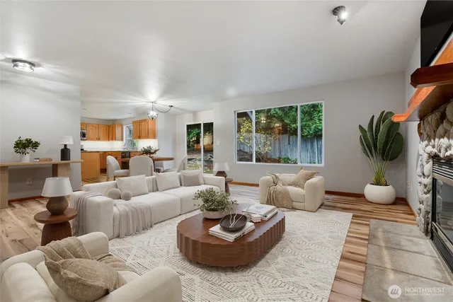 a living room with furniture potted plant and a large window