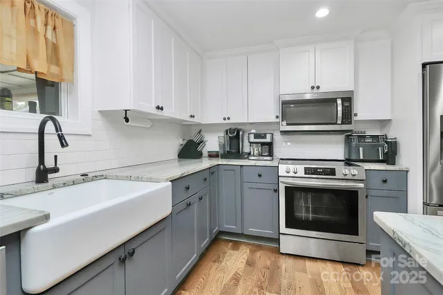 a kitchen with sink a microwave and cabinets