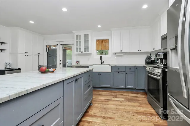 a kitchen with stainless steel appliances granite countertop a sink counter space cabinets and a large window
