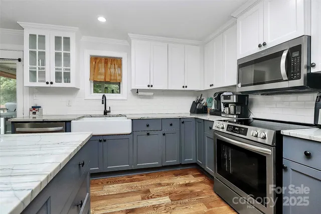 a kitchen with stainless steel appliances granite countertop a stove a sink and a microwave