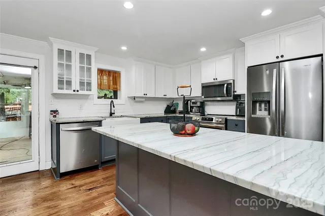 a kitchen with a refrigerator a sink a stove a microwave and cabinets