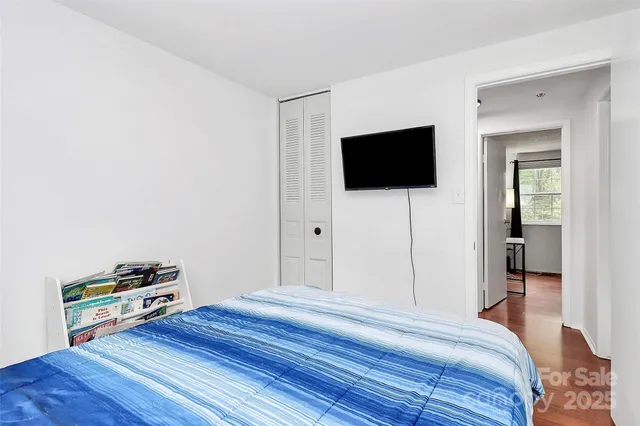 a bedroom with a bed and a a flat screen tv