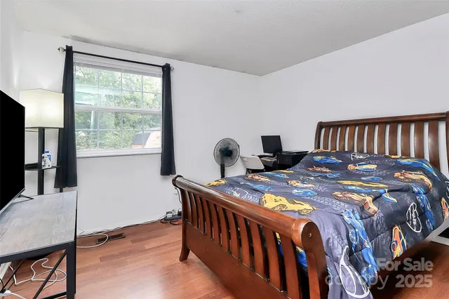 a bedroom with a bed and wooden floor