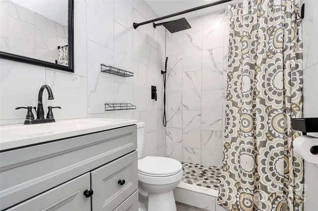 a bathroom with a sink toilet and shower