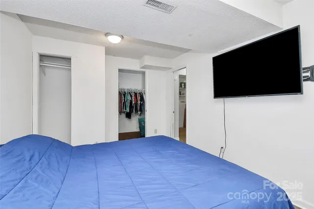 a view of an empty room with wooden floor and a flat screen tv