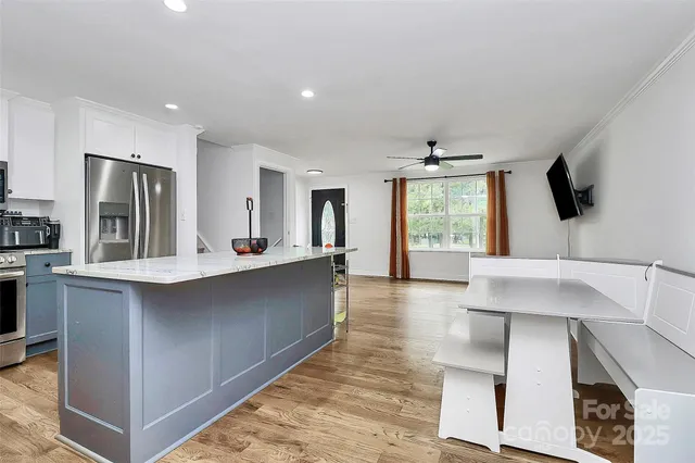 a large kitchen with kitchen island a sink stainless steel appliances and cabinets