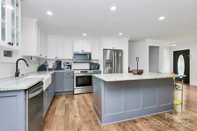 a kitchen with stainless steel appliances granite countertop a sink stove and refrigerator