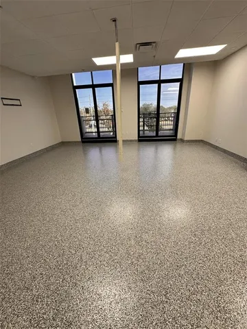 an empty room with a fireplace and windows