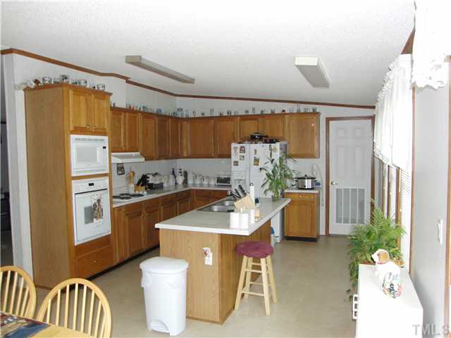 1224 Roffler Street Garner, NC 27529 - Photo 2 of 14 Very Spacious with lots of Natural Light! Notice the wall ovens and center island w/bar seating. Lots of cabinets and counterspace. Good Quality Cabinetry! Microwave & Self Clean Oven. Large Laundry/Utility room is off the kitchen