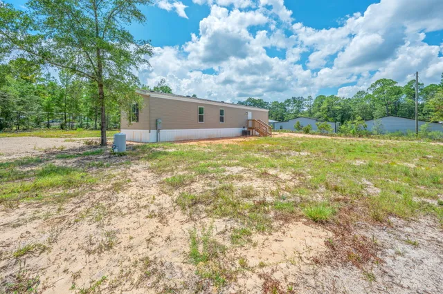 a backyard of a house with table and chairs