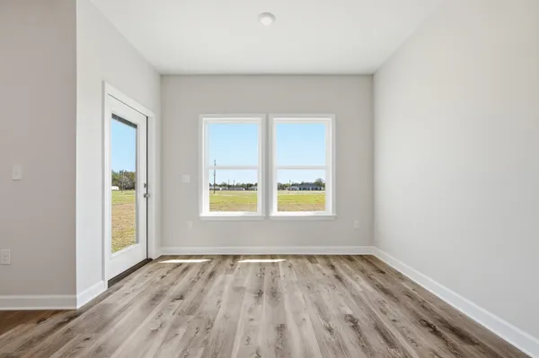 an empty room with a window and wooden floor