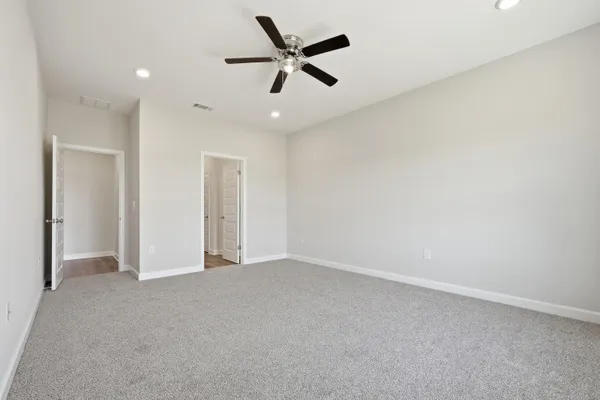 an empty room with closet and a ceiling fan