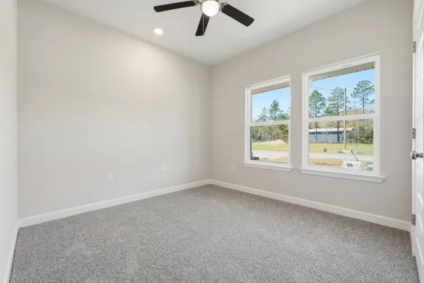 an empty room with a window and a ceiling fan