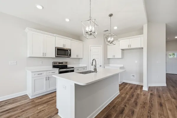 a kitchen with a sink stainless steel appliances cabinets and a window