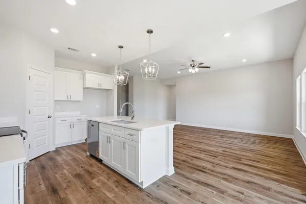 a kitchen with a sink cabinets and wooden floor