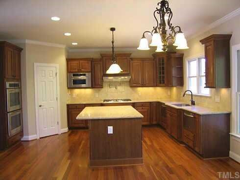 7409 Chesley Lane Durham, NC 27713 - Photo 2 of 10 a large kitchen with kitchen island a chandelier wooden floor and a chandelier