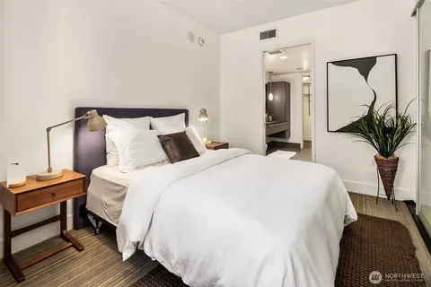 a bedroom with a bed and a large mirror