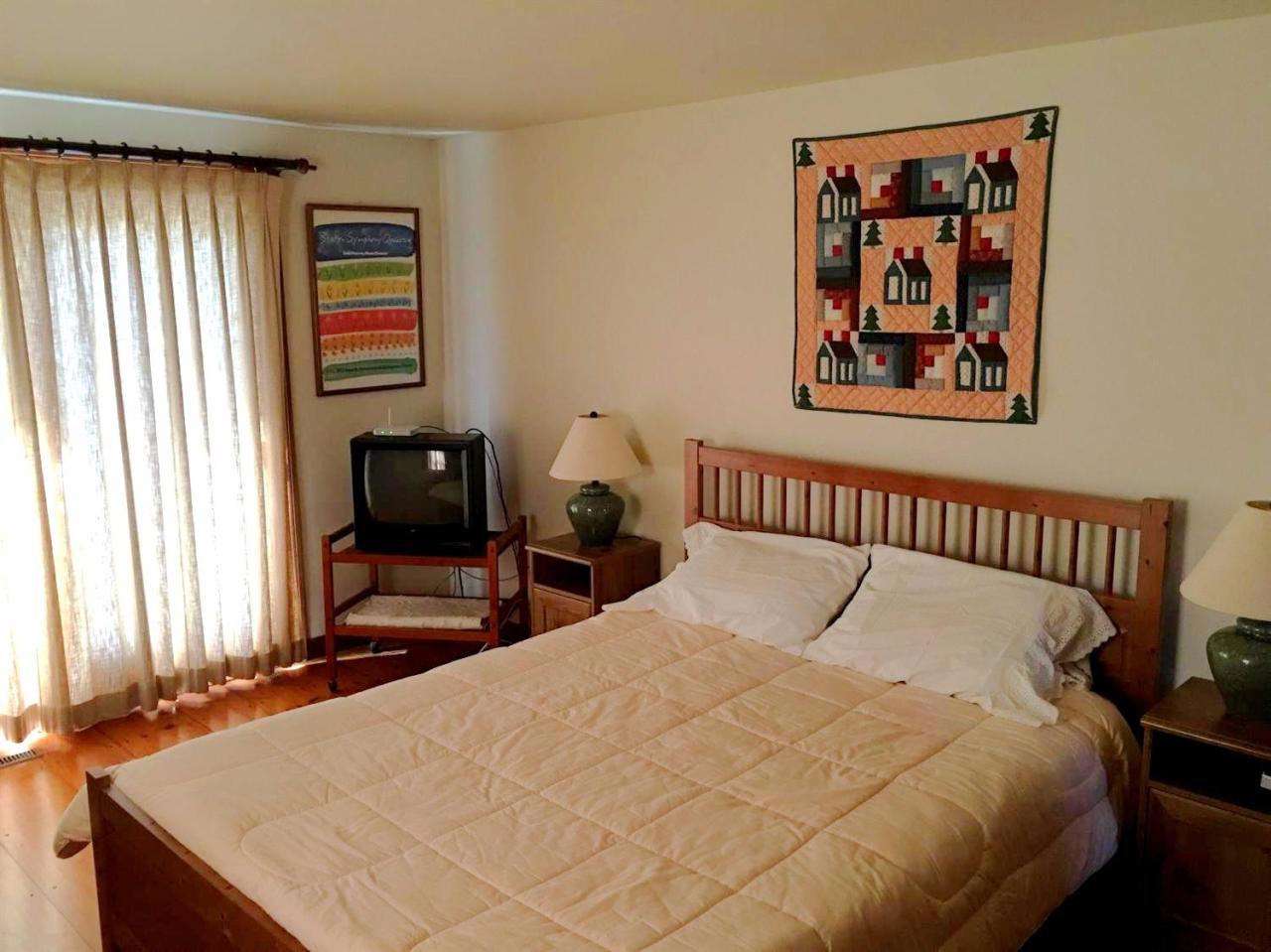 35 Split Rail Road Eastham, MA 02642 - Photo 17 of 28 a bed sitting in a bedroom next to a window with chair and a large window