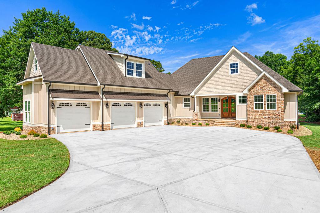 707 Vickery Street Extension Hartwell, GA 30643 - Photo 1 of 50 A spacious concrete driveway leads to a striking home featuring a blend of natural stone and classic siding.