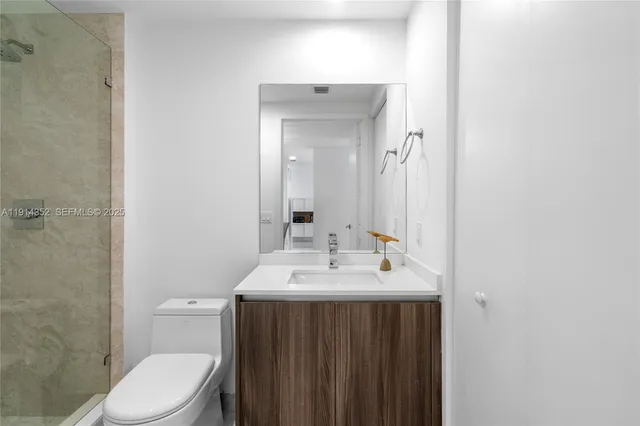 a bathroom with a sink a toilet and mirror