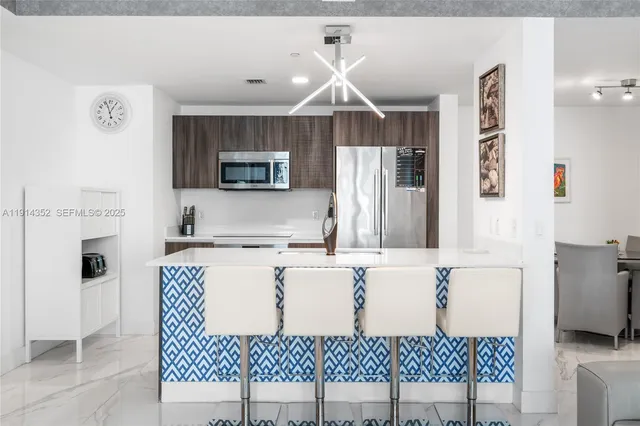 a kitchen with a sink a microwave a refrigerator and cabinets