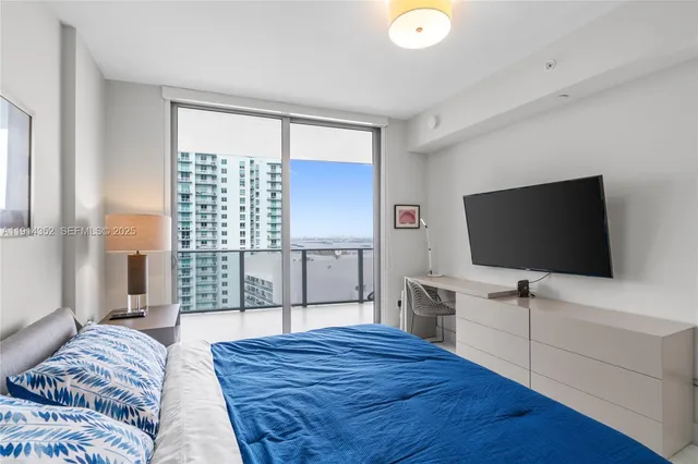 a bedroom with a bed and a flat screen tv