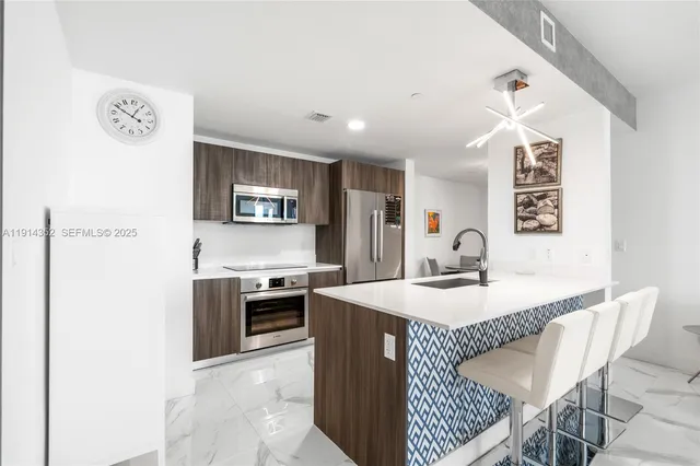 a kitchen with kitchen island a stove a sink and a refrigerator