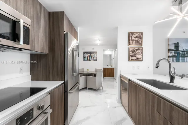 a kitchen with stainless steel appliances granite countertop a sink and a stove