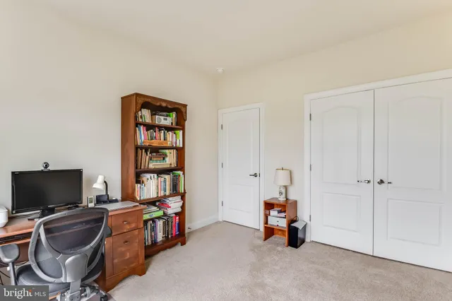 a view of a livingroom with workspace and a window