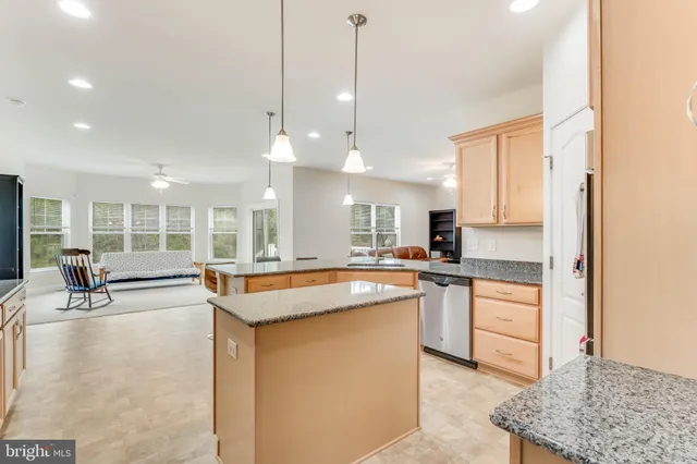 a large kitchen with kitchen island a large counter top space a sink stainless steel appliances and cabinets