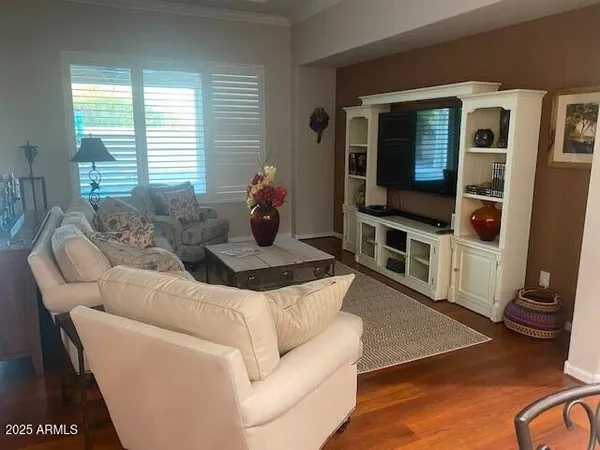 a living room with furniture tv and wooden floor