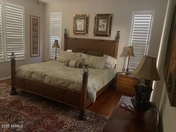 a bedroom with a bed and wooden floor