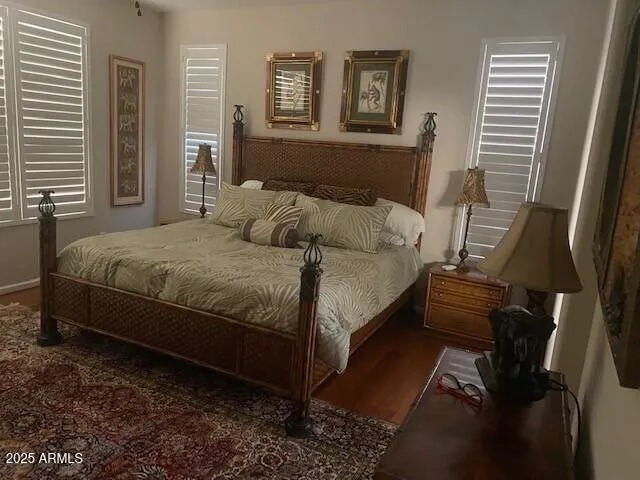 a bedroom with a bed and wooden floor