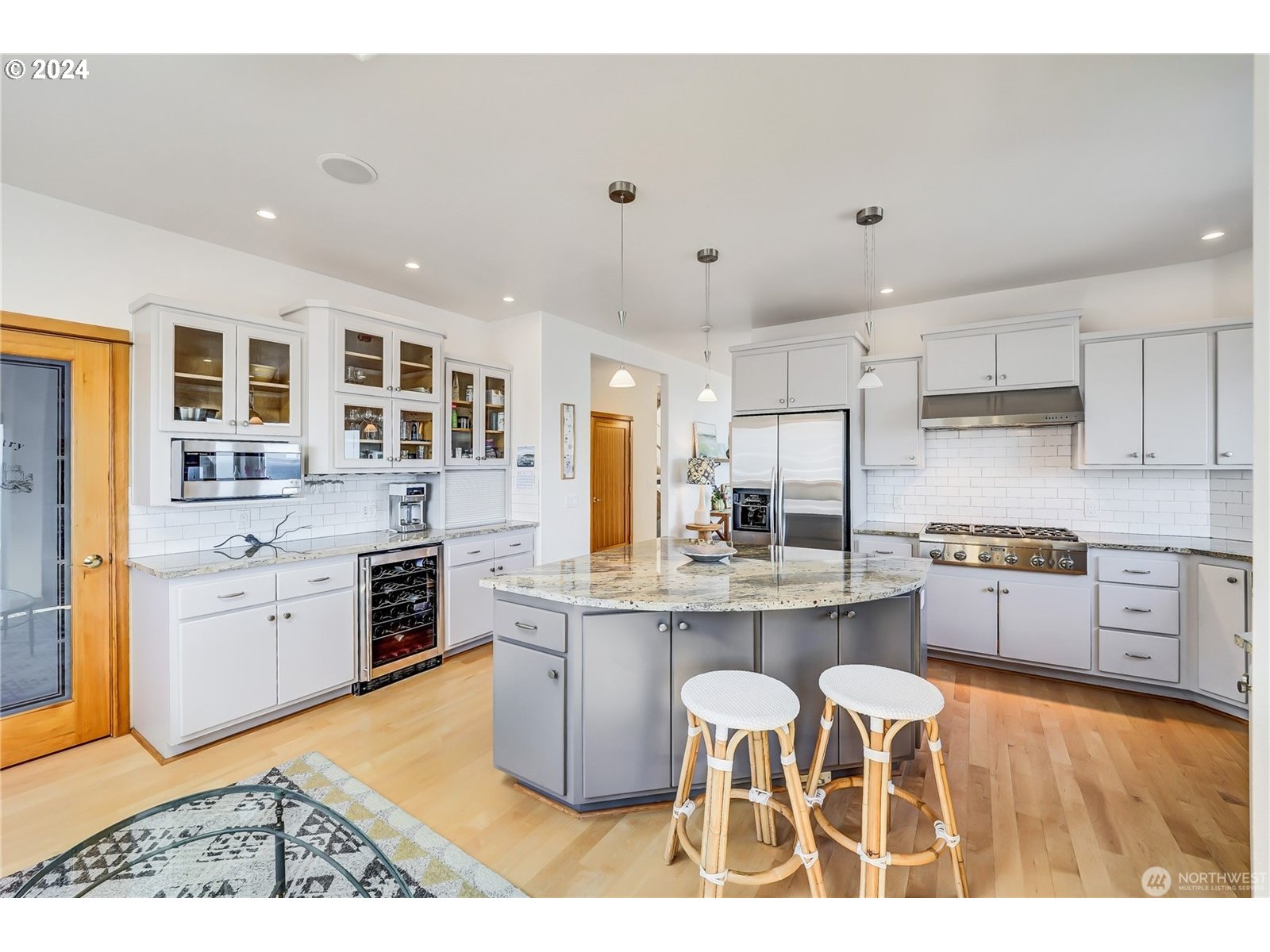 4844 G Loop Bow, WA 98232 - Photo 9 of 40 a kitchen with stainless steel appliances kitchen island granite countertop a stove top oven a sink dishwasher a dining table and chairs with wooden floor