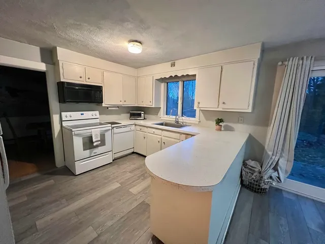 a kitchen with a sink a white cabinets and stainless steel appliances
