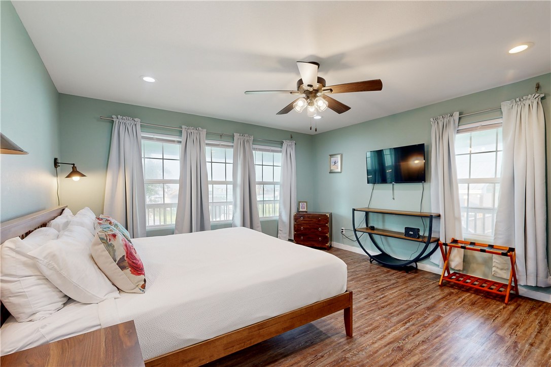 370-374 Copano Ridge Road Rockport, TX 78382 - Photo 11 of 40 a bedroom with a large bed a large window and flat screen tv