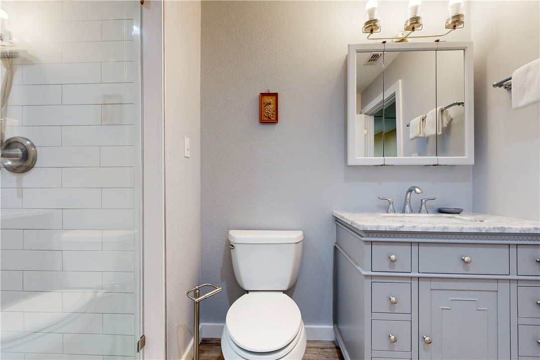 370-374 Copano Ridge Road Rockport, TX 78382 - Photo 12 of 40 a bathroom with a granite countertop toilet sink and mirror