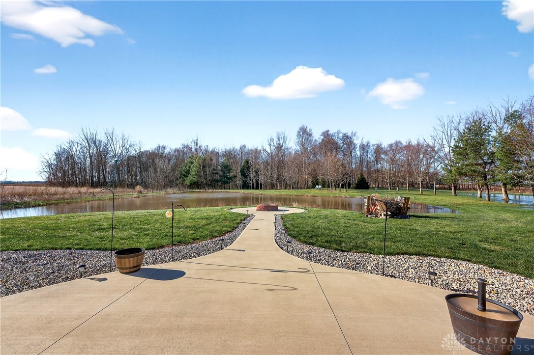 6560 Snyder Road Fletcher, OH 45326 - Photo 52 of 71 This serene outdoor space features a concrete patio leading to a charming fire pit by the tranquil pond.
