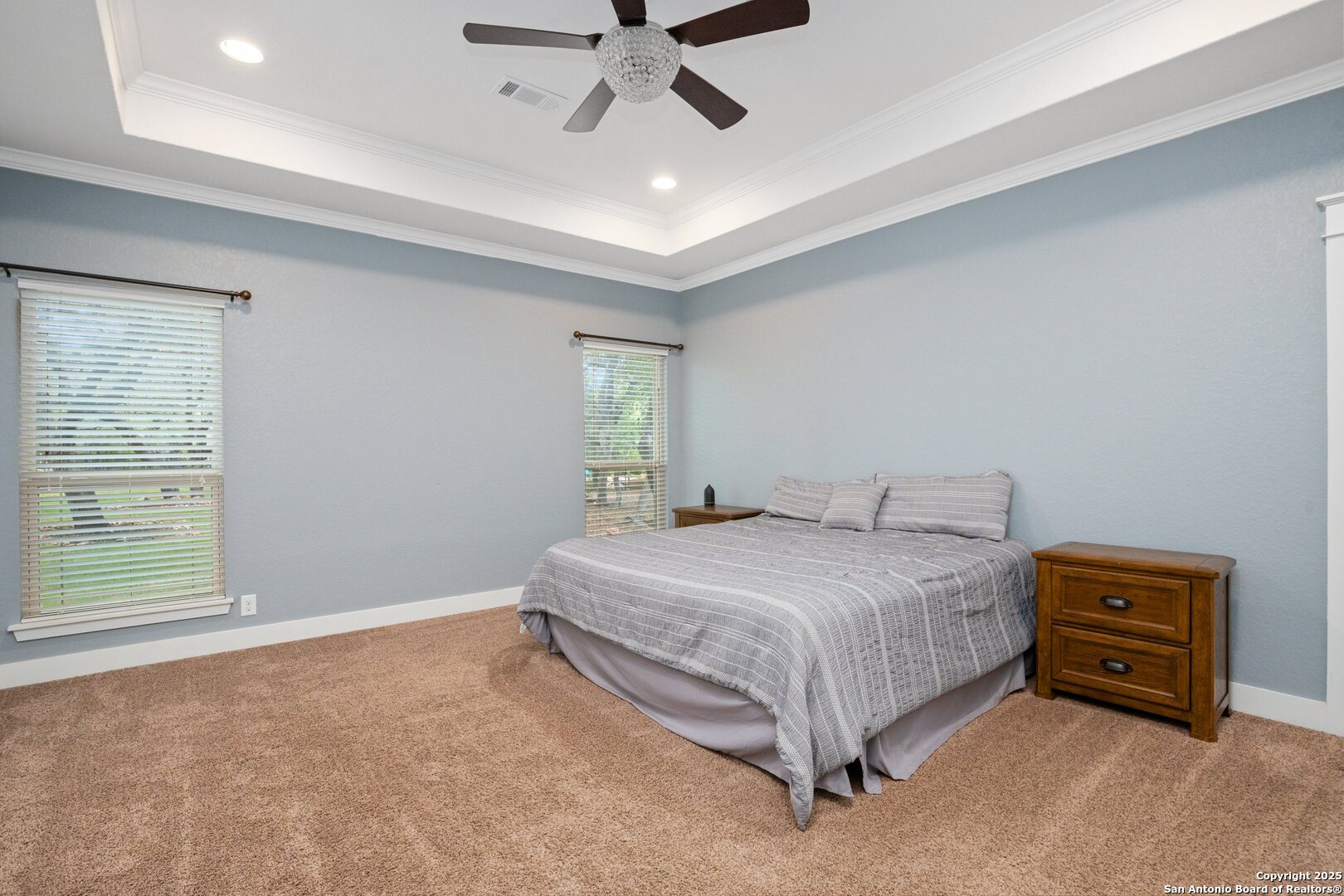 10015 Kopplin Road New Braunfels, TX 78132 - Photo 19 of 38 a spacious bedroom with a bed and a chandelier