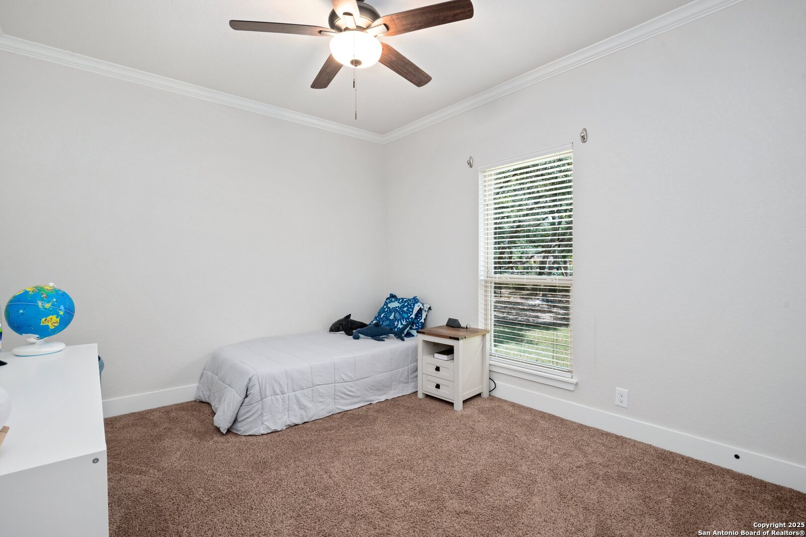 10015 Kopplin Road New Braunfels, TX 78132 - Photo 21 of 38 a bedroom with a bed and a chandelier