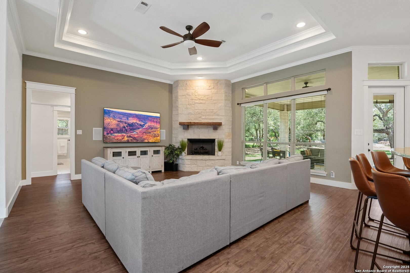 10015 Kopplin Road New Braunfels, TX 78132 - Photo 6 of 38 a living room with furniture a flat screen tv and a floor to ceiling window