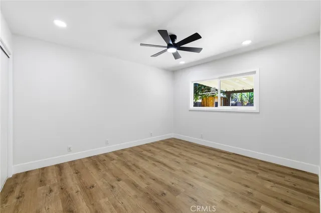 a view of a big room with wooden floor and windows