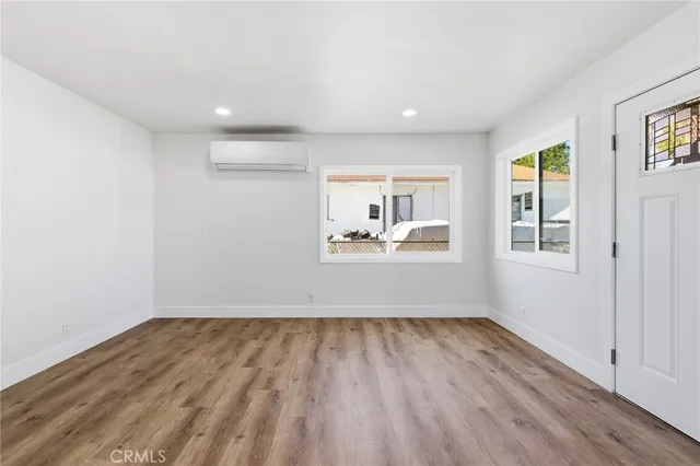 a room with a wooden floor and a window