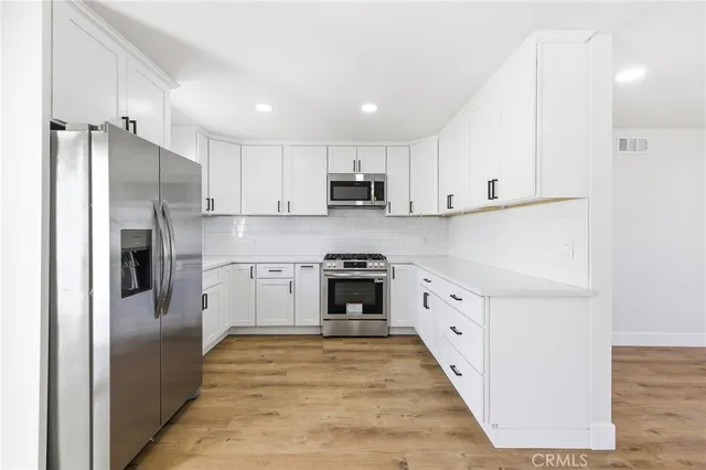 a kitchen with cabinets and a refrigerator
