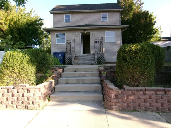 a front view of a house with plants