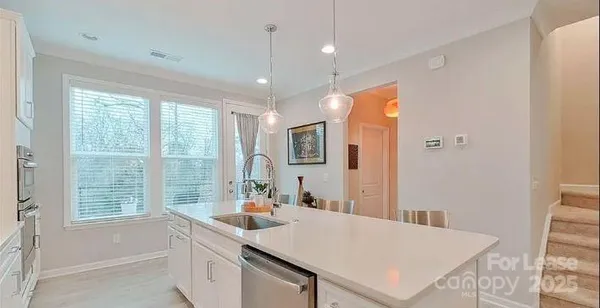 a kitchen with stainless steel appliances granite countertop a refrigerator a sink a stove and a refrigerator with wooden floor