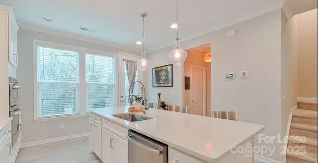 a kitchen with stainless steel appliances granite countertop a refrigerator a sink a stove and a refrigerator with wooden floor