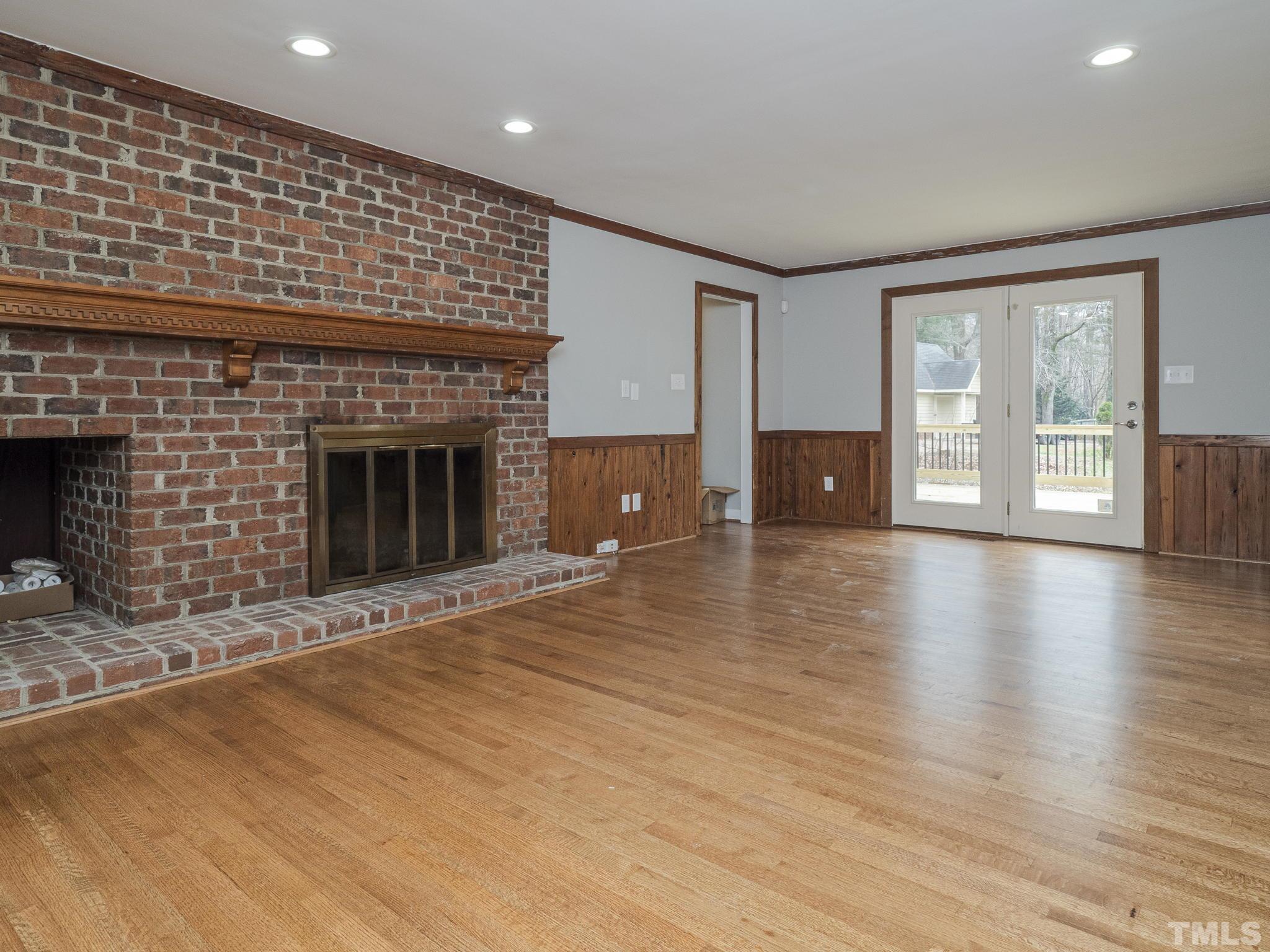 9408 Barton Creek Road Raleigh, NC 27615 - Photo 11 of 20 an empty room with wooden floor and fireplace