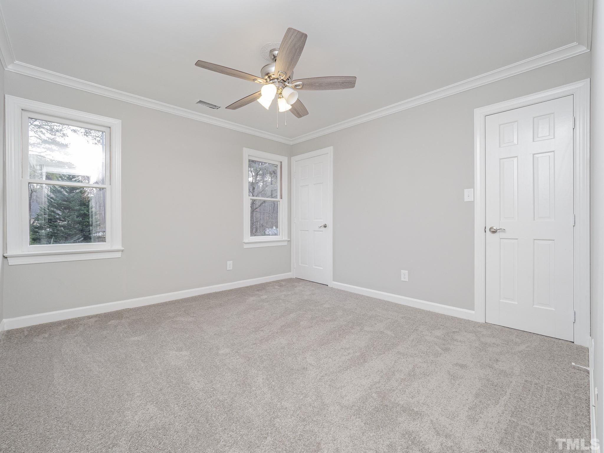 9408 Barton Creek Road Raleigh, NC 27615 - Photo 16 of 20 a view of an empty room with chandelier fan and fire place