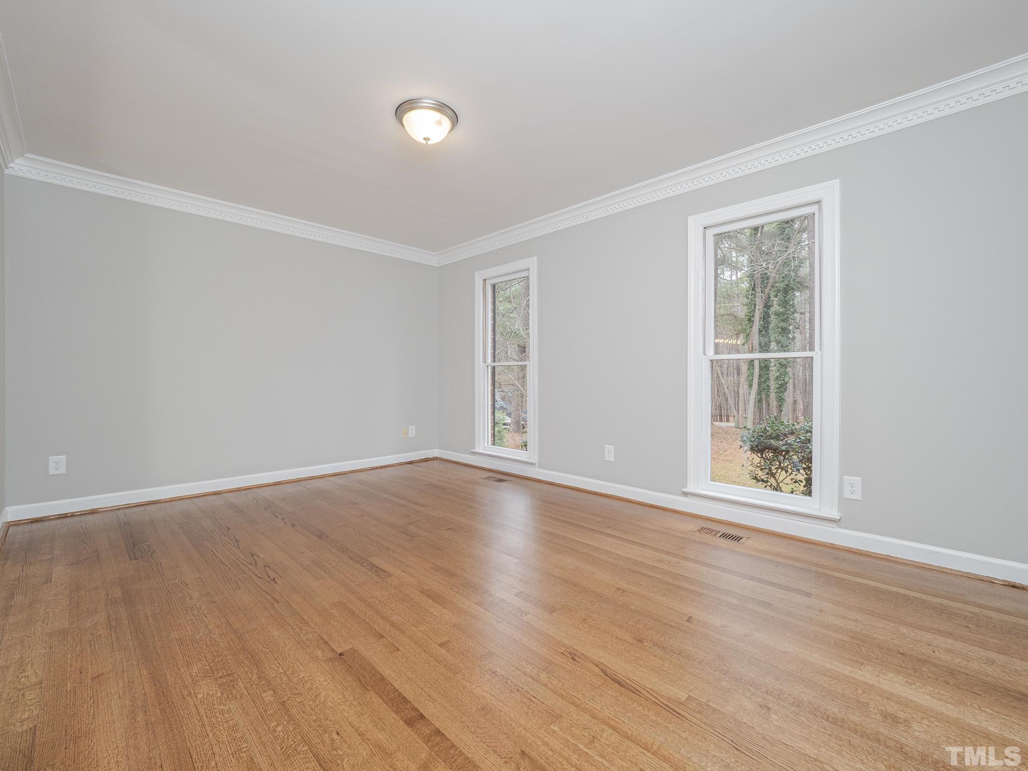 9408 Barton Creek Road Raleigh, NC 27615 - Photo 6 of 20 a view of an empty room with wooden floor and a window